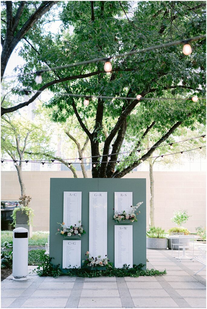 Wedding seating chart outside by a tree with spring lights at Dallas Meyerson Symphony Center Wedding