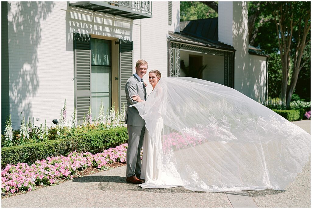 Wedding portraits outside with brides veil blowing in the wind