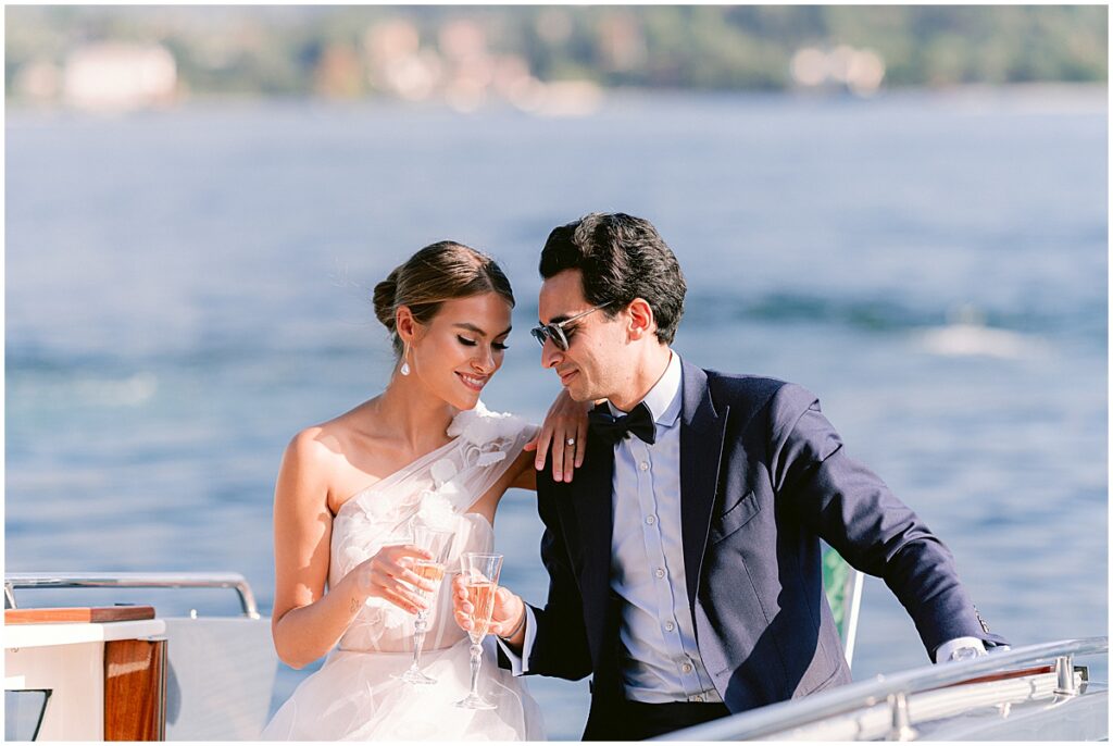 Bride and groom with champagne glasses on Lake Como