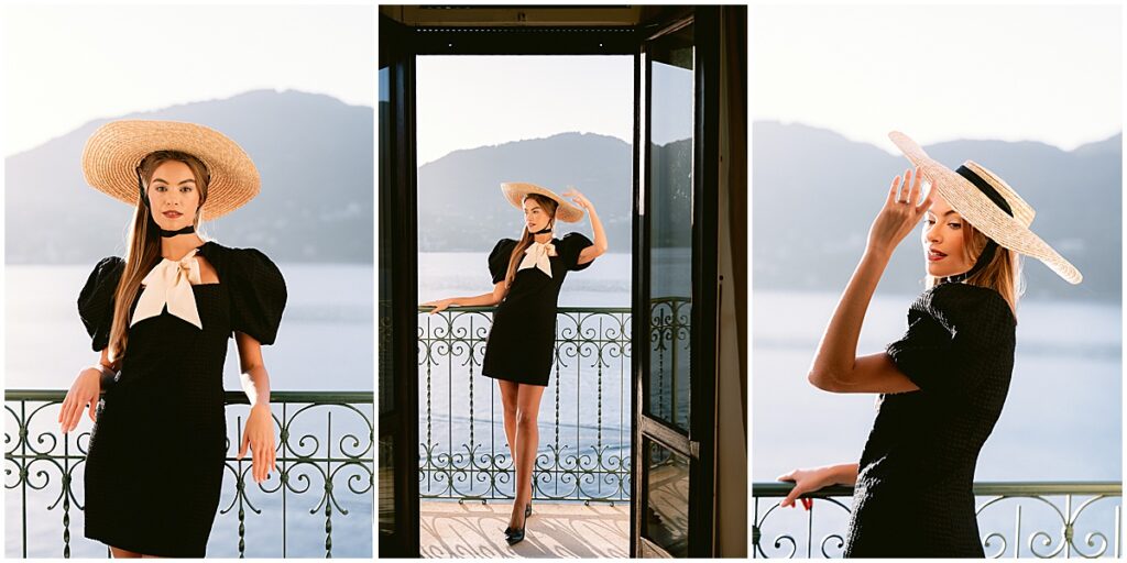 Woman wearing straw hat, black and white dress standing on balcony of hotel Tremezzo.