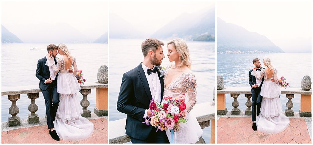 Bride and groom on the shore of lake como, groom wearing black tuxedo and bride wearing tiered lace dress holding a colorful bouquet
